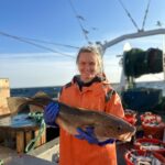 student holding a fish